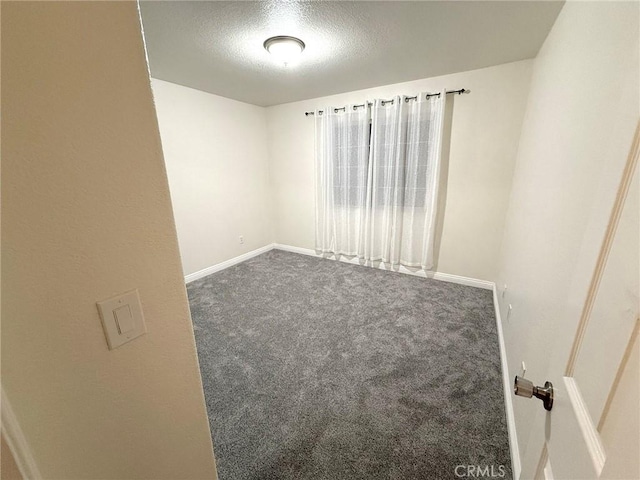 carpeted spare room featuring a textured ceiling