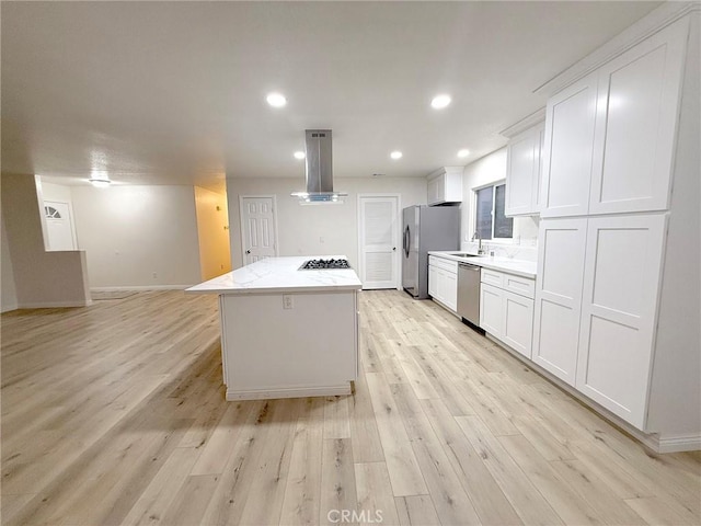 kitchen with ventilation hood, white cabinets, appliances with stainless steel finishes, and light hardwood / wood-style flooring