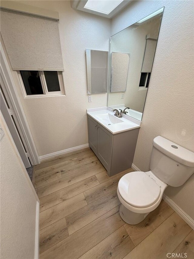 bathroom featuring hardwood / wood-style floors, vanity, and toilet