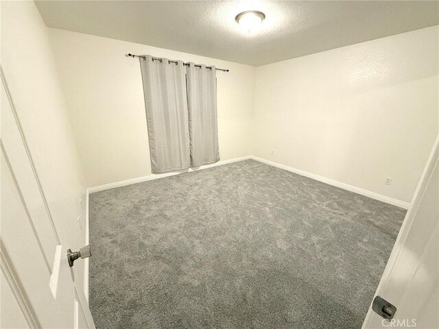 carpeted spare room featuring a textured ceiling