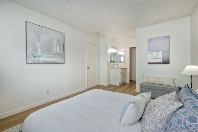 bedroom with light hardwood / wood-style floors and a textured ceiling