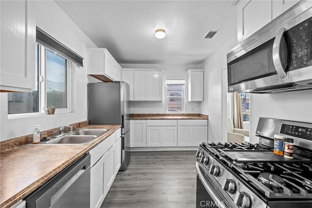 kitchen featuring white cabinets, sink, and appliances with stainless steel finishes