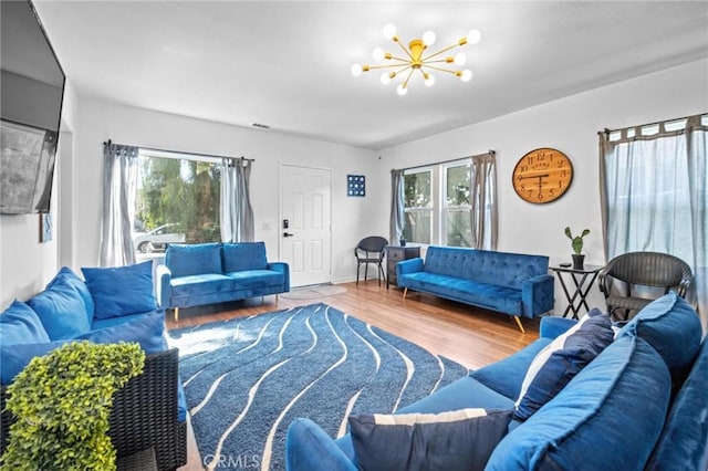 living room with hardwood / wood-style floors, plenty of natural light, and a notable chandelier