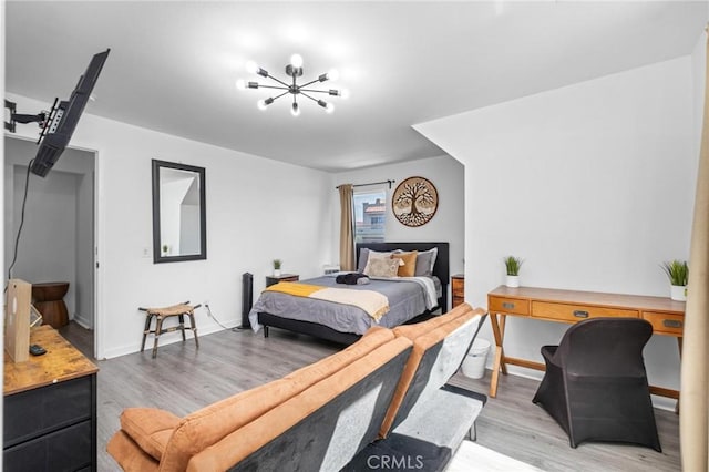 bedroom with an inviting chandelier and light hardwood / wood-style flooring