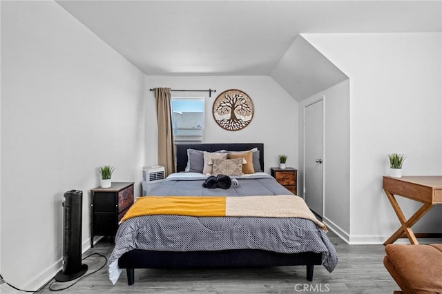 bedroom with wood-type flooring and lofted ceiling