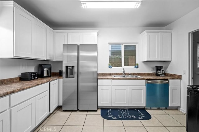 kitchen featuring white cabinets, appliances with stainless steel finishes, light tile patterned floors, and sink