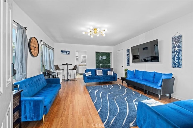 living room featuring wood-type flooring and an inviting chandelier