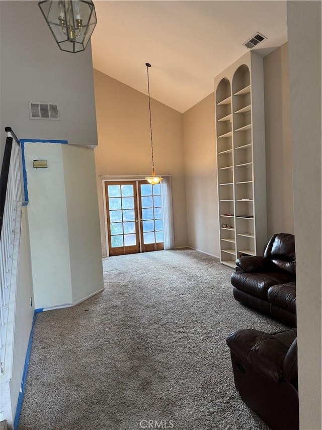 sitting room featuring high vaulted ceiling, french doors, and carpet