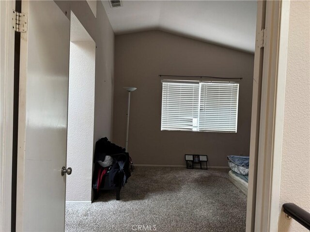 interior space featuring carpet floors and vaulted ceiling