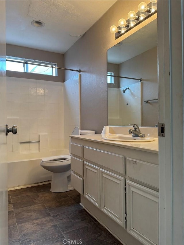 full bathroom with vanity, a textured ceiling, shower / tub combination, and toilet