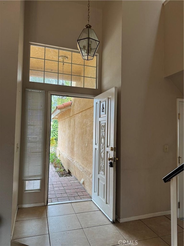 foyer featuring light tile patterned floors and a high ceiling