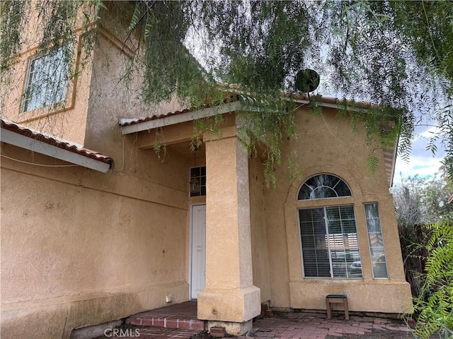 view of exterior entry featuring a patio area