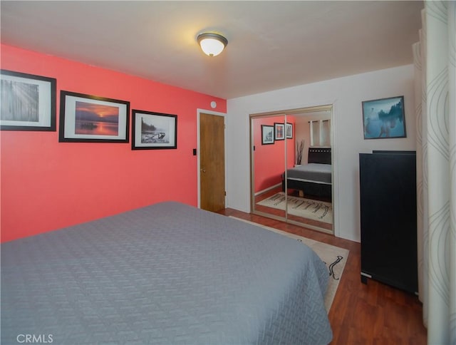 bedroom with a closet and dark hardwood / wood-style floors