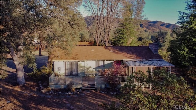 rear view of house with a deck with mountain view