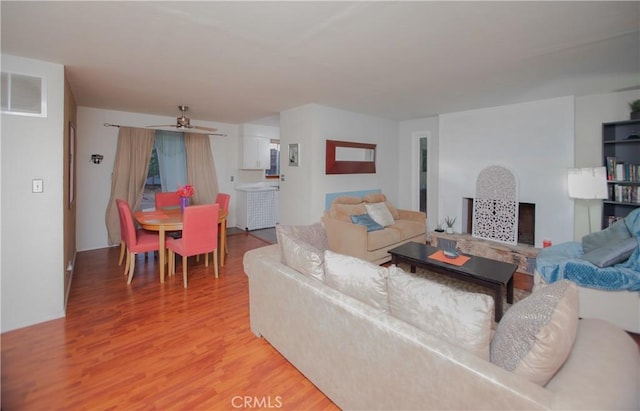 living room featuring hardwood / wood-style floors and ceiling fan