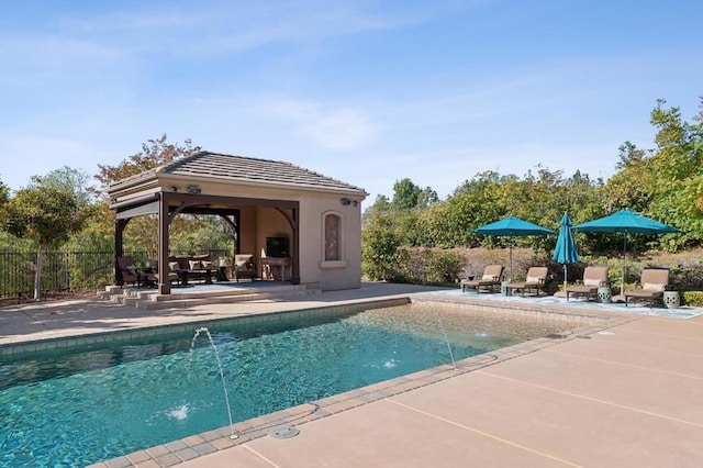 view of pool featuring an outdoor fireplace, a patio area, and pool water feature