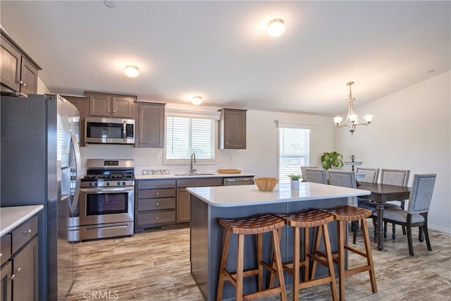 kitchen with appliances with stainless steel finishes, light hardwood / wood-style floors, a healthy amount of sunlight, and sink