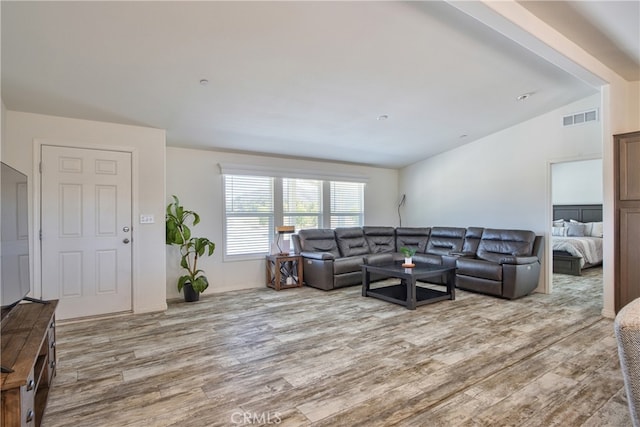 living room with light hardwood / wood-style flooring and lofted ceiling