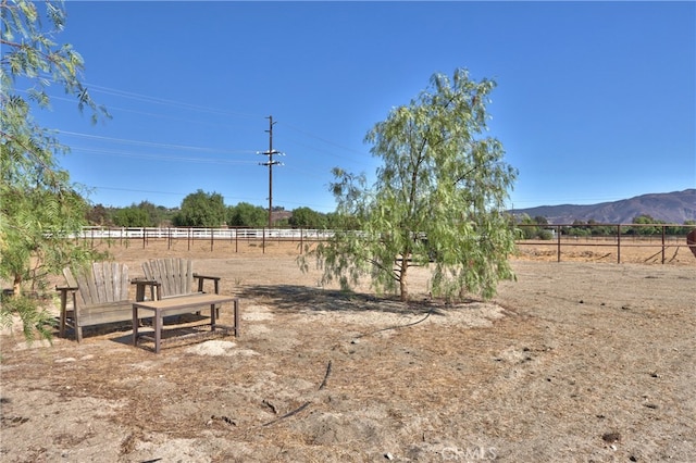 view of yard with a mountain view and a rural view