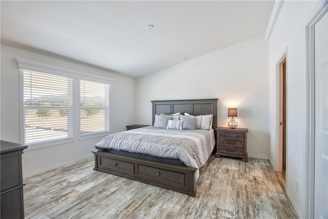 bedroom with light hardwood / wood-style flooring and vaulted ceiling