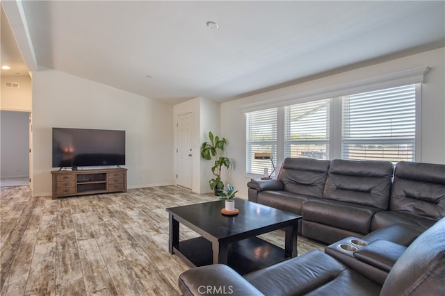 living room with light wood-type flooring and vaulted ceiling