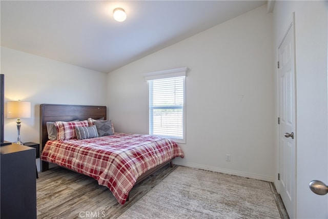 bedroom with light wood-type flooring and vaulted ceiling