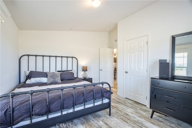 bedroom with vaulted ceiling and light hardwood / wood-style flooring