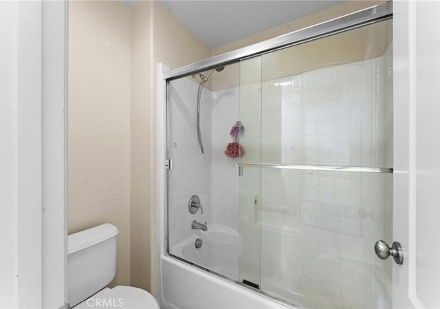 bathroom featuring shower / bath combination with glass door and toilet