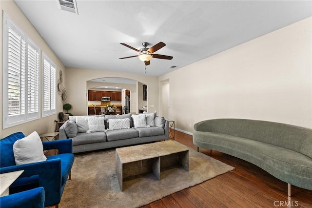 living room with ceiling fan and dark hardwood / wood-style flooring