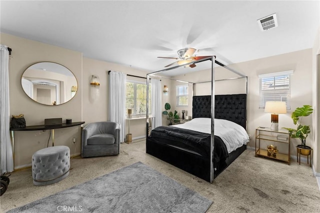 carpeted bedroom with multiple windows and ceiling fan