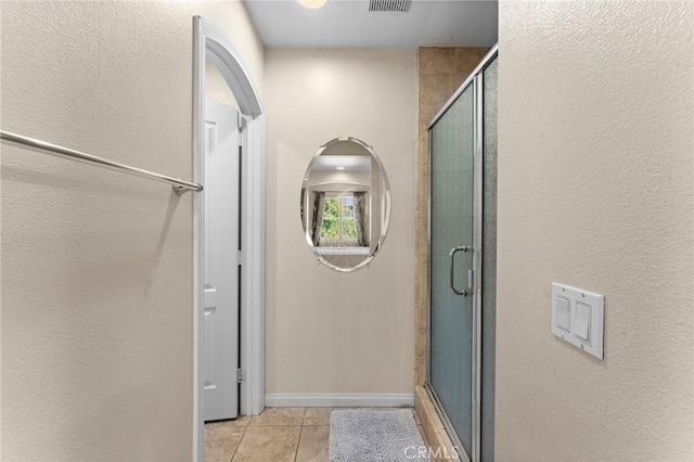 bathroom with tile patterned floors and a shower with shower door