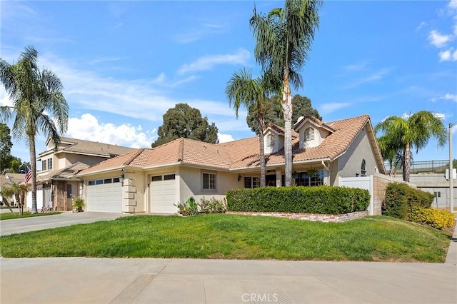 mediterranean / spanish home featuring a front yard and a garage