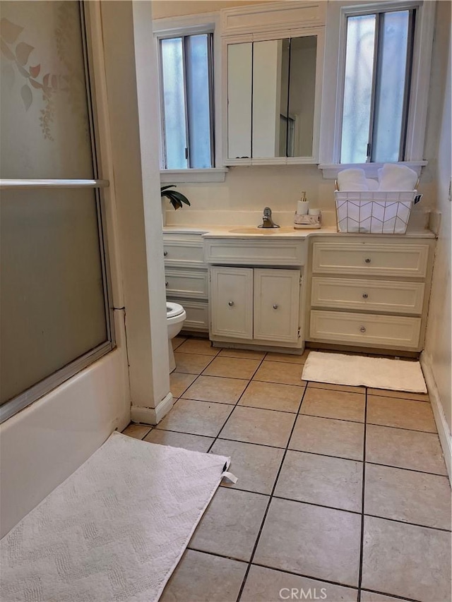 full bathroom featuring vanity, toilet, tile patterned flooring, and a wealth of natural light