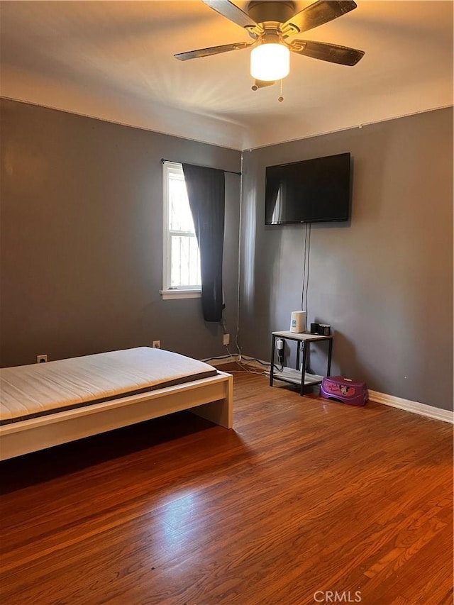 unfurnished bedroom featuring hardwood / wood-style floors and ceiling fan