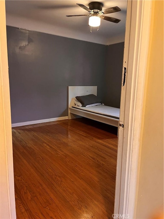 unfurnished bedroom with ceiling fan and wood-type flooring