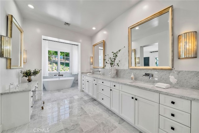 bathroom with a bathtub, backsplash, and vanity