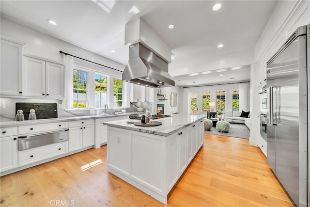 kitchen with white cabinetry, stainless steel appliances, a healthy amount of sunlight, and light hardwood / wood-style floors