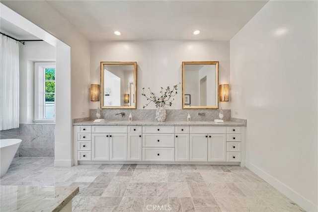 bathroom with vanity and a washtub