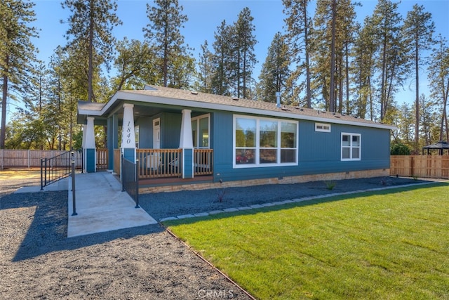 rear view of house with a yard and a porch