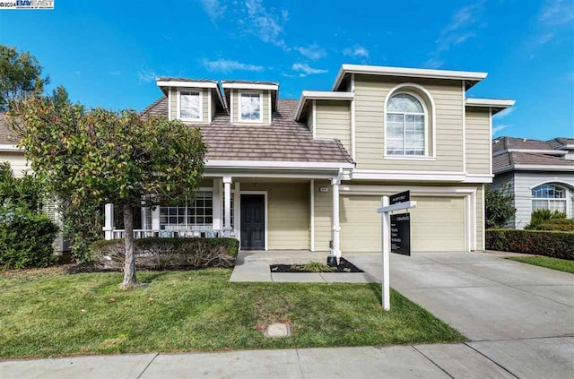 view of front of property with a porch, a garage, and a front lawn