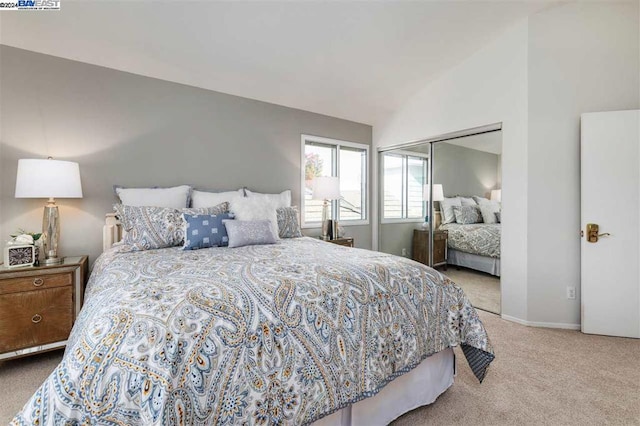 bedroom featuring light carpet, a closet, and lofted ceiling