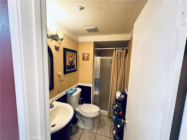 bathroom with baseboard heating, sink, tile patterned flooring, toilet, and a shower with shower door