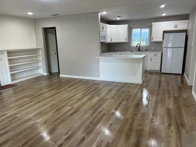 kitchen featuring white cabinetry, sink, dark wood-type flooring, and white appliances