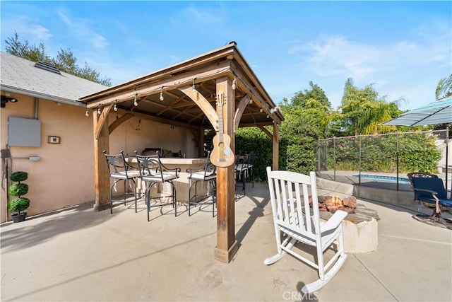 view of patio / terrace with a gazebo, a bar, and a fire pit