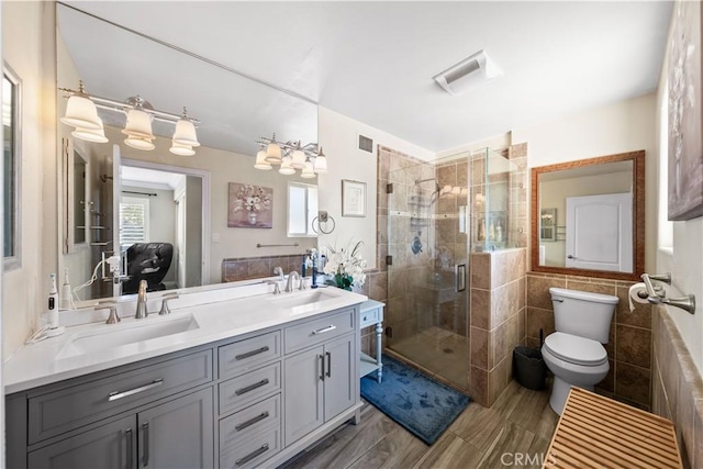 bathroom featuring an enclosed shower, vanity, wood-type flooring, tile walls, and toilet