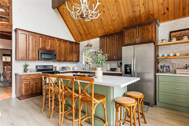 kitchen featuring a notable chandelier, appliances with stainless steel finishes, a center island, and a kitchen bar