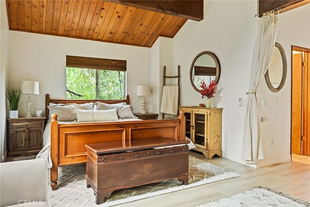 bedroom featuring vaulted ceiling with beams, light hardwood / wood-style floors, and wooden ceiling