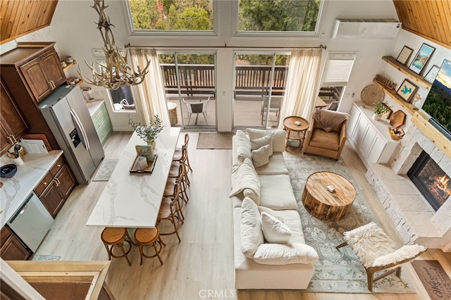 living room with light hardwood / wood-style floors and a towering ceiling