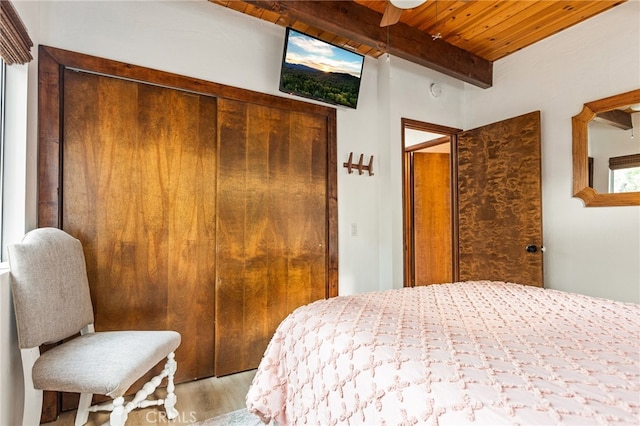 bedroom featuring wood ceiling, a closet, beamed ceiling, light wood-type flooring, and ceiling fan