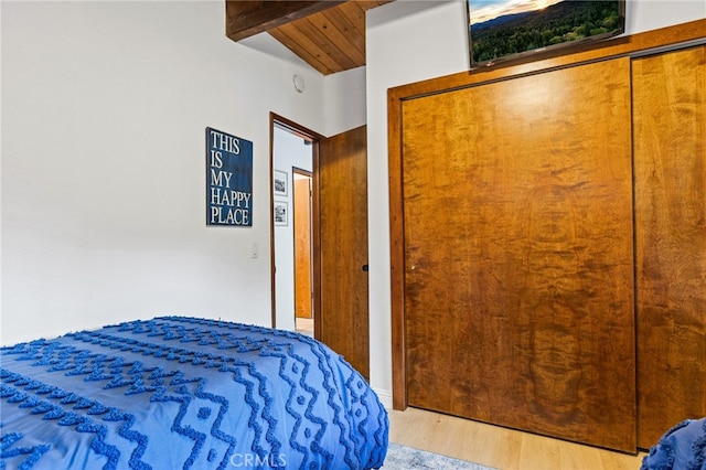 bedroom with vaulted ceiling with beams, wood ceiling, and light hardwood / wood-style floors